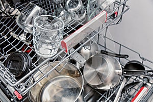 Various kitchen utensils loaded into the dishwasher inside