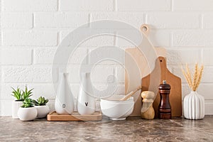 Various kitchen utensils on a marble countertop in a modern kitchen. the concept of decor against the background of a white brick