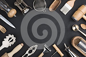 Various kitchen utensils set on black background with copy space