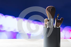 Various make up brushes in container on table