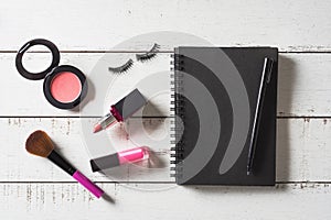 Various make-up products and cosmetics on wooden table