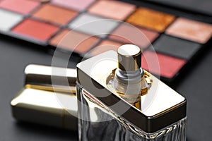 various makeup products on black texture background.