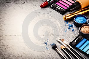 Various makeup products on dark background