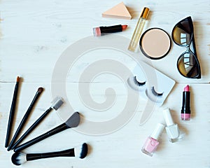 Various makeup products on wooden background with copyspace