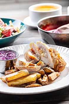 Various meals served on plates with cordon bleu with baked potatoes in the front