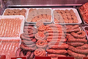 Various meat in a supermarket. Different meat products in the butchery. Raw sausages and meatballs