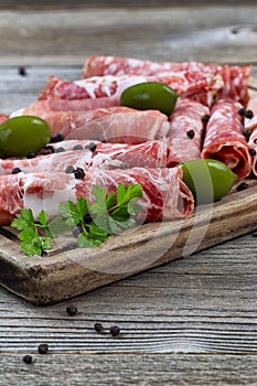 Various meats on serving board with rustic background