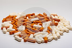 A big pile of white pills and orange pills