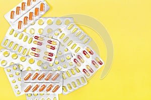 Various medicine pills on yellow background. Top view, copy space
