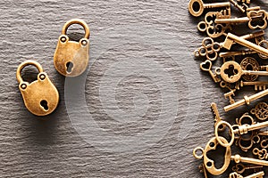 Various metal keys and locks on slate background