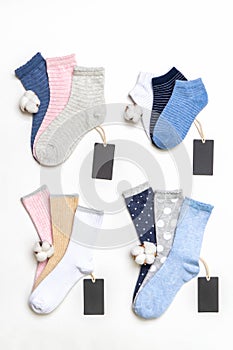 Various modern trendy women`s cotton socks set with cotton flowers and price tags on white background. Fashionable socks store.