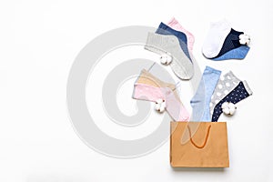 Various modern trendy women`s cotton socks set with cotton flowers in shopping bag on white background. Fashionable socks store.