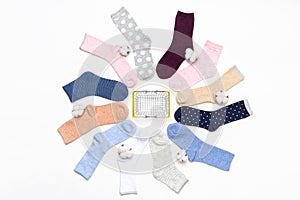 Various modern trendy women`s cotton socks set with cotton flowers and shopping basket on white background. Fashionable socks