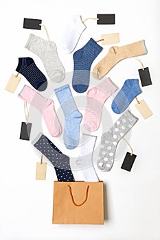 Various modern trendy women`s cotton socks set with price tags in shopping bag on white background. Fashionable socks store. Sock