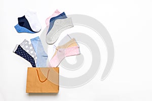 Various modern trendy women`s cotton socks set in shopping bag on white background. Fashionable socks store. Socks shopping, sale