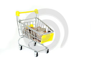 Various money coins Baht in yellow mini shopping cart or supermarket trolley isolated on white background.