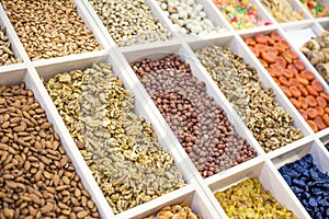 Various nuts and dried fruits on the market: hazelnuts, almonds, peanuts, cashews, raisins, candied fruits, dried fruits, prunes