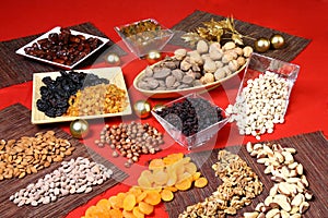Various nuts and dried fruits in pots on the red table