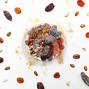 Various nuts and dried fruits, on a white-gold background. Vegan and vegetarian concept, healthy source of fat. Healthy snack