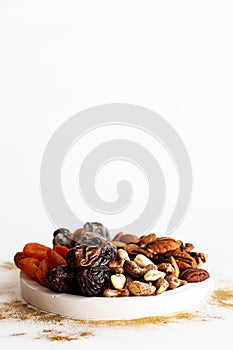 Various nuts and dried fruits, on a white-gold background. Vegan and vegetarian concept, healthy source of fat. Healthy snack
