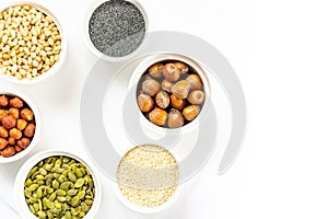 Various Nuts and Seeds on White Background in the Bowls with Free Space for Text