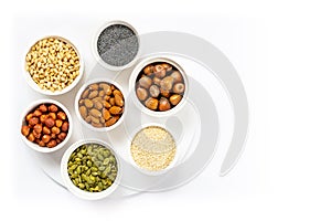 Various Nuts and Seeds on White Background in the Bowls with Free Space for Text