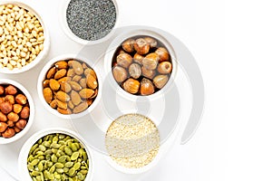 Various Nuts and Seeds on White Background in the Bowls with Free Space for Text