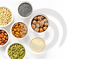 Various Nuts and Seeds on White Background in the Bowls with Free Space for Text