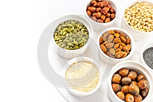 Various Nuts and Seeds on White Background in the Bowls with Free Space for Text