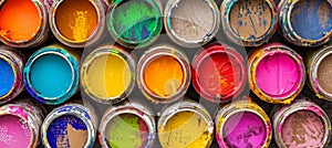 Various open paint cans displayed on a vivid and vibrant multicolored background