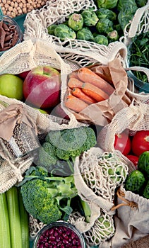 Various organic fruits and vegetables in reusable packaging bags