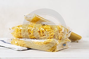 Various pasta in transparent plastic bags on a kitchen table