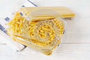 Various pasta in transparent plastic bags on a kitchen table