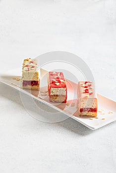 Various pastries on a white plate and a light background. Dessert for Mother`s Day