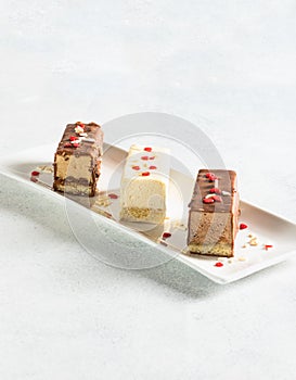 Various pastries on a white plate and a light background. Dessert for Mother`s Day