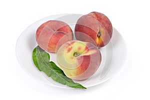 Various peaches and peach tree leaf on the white dish