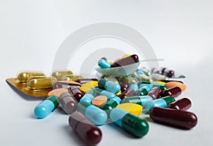 Various pharmaceutical medicine pills, orange tablets, blue and green capsules