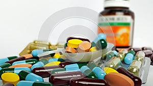 Various pharmaceutical medicine pills, orange tablets, blue and green capsules