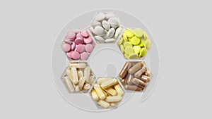 Various pills and capsules appear on a grey background