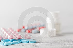 Various pills and capsules in blister packagings piled up on a t