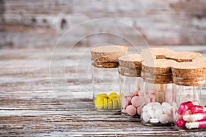 Various pills and capsules in containers with caps