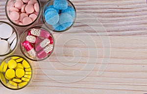 Various pills and capsules in glass containers top view