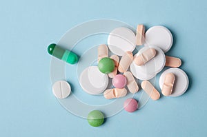 Various pills and capsules of medicine, top view on blue background; safe drugs use and medical treatment concept