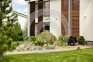 Various plants and stones in front of modern house, front yard. Landscape design. Beautiful garden. Modern urban living