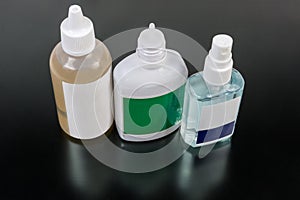 Various plastic bottles of antiseptics on a dark surface