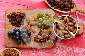 Various raisins, vine berries and almonds on chopping board
