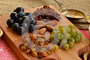 Various raisins, vine berries and almonds on chopping board