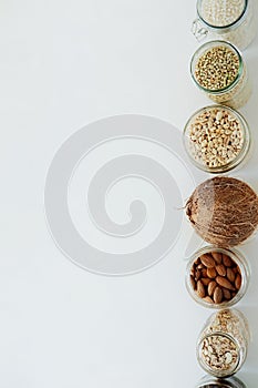 Various raw cereals, grains in glass jars.