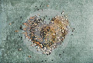 Various raw grains, beans and cereals in shape of heart