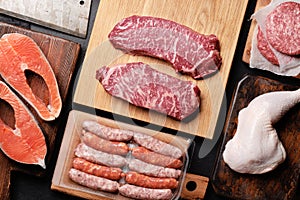 Various raw meat and fish. Steaks, sausages, salmon, chicken and spices